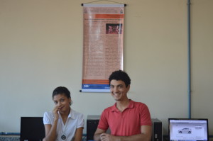Letícia Santos (Bolsista Voluntária do CEPAP-UNIFAP) e Anderson Rocha (Estudante da UNIFAP) com seu poster ao fundo.