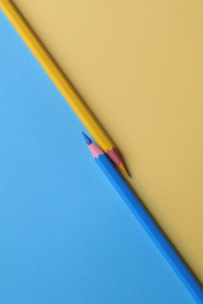 hero-contact Close-up of vibrant yellow and blue colored pencils on contrasting paper backgrounds.